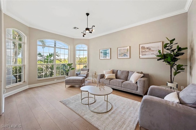 living area featuring baseboards, crown molding, visible vents, and wood finished floors