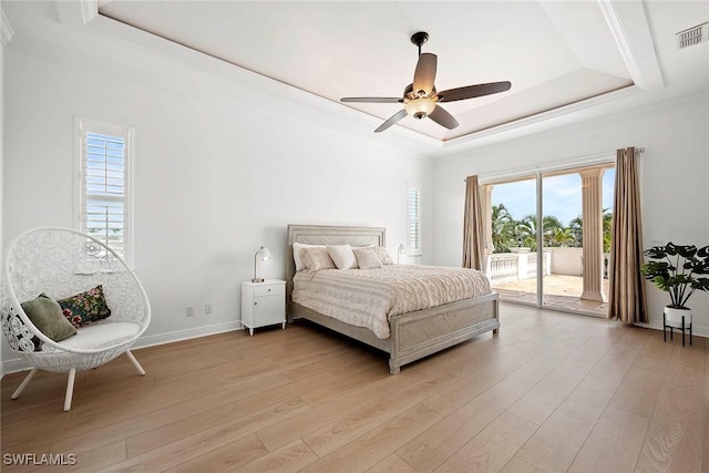 bedroom featuring light wood-style floors, visible vents, access to exterior, and a tray ceiling