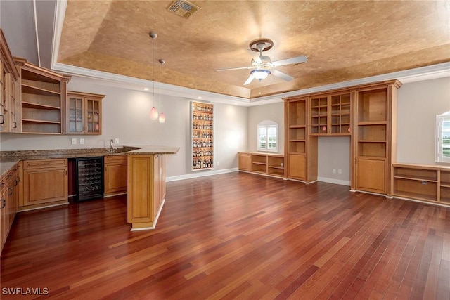 bar featuring beverage cooler, a sink, visible vents, a tray ceiling, and dark wood finished floors