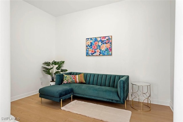 living area with baseboards and wood finished floors