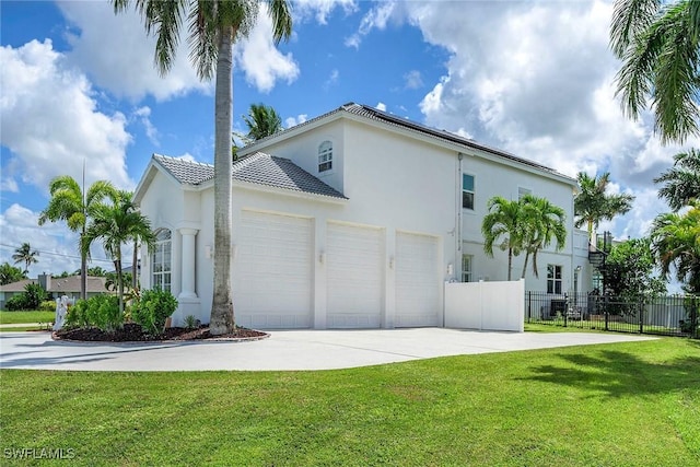 view of side of property featuring a yard, stucco siding, an attached garage, fence, and driveway