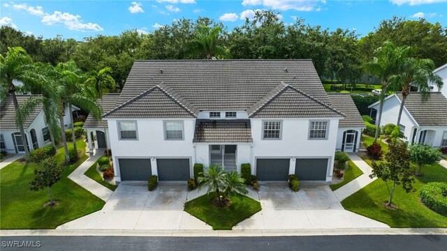 1010 Partridge Cir Unit 202, Naples, FL 34104 - view of front of house featuring a garage, driveway, a tile roof, and a front yard