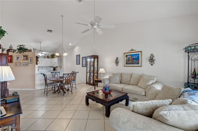 tiled living room featuring ceiling fan and high vaulted ceiling