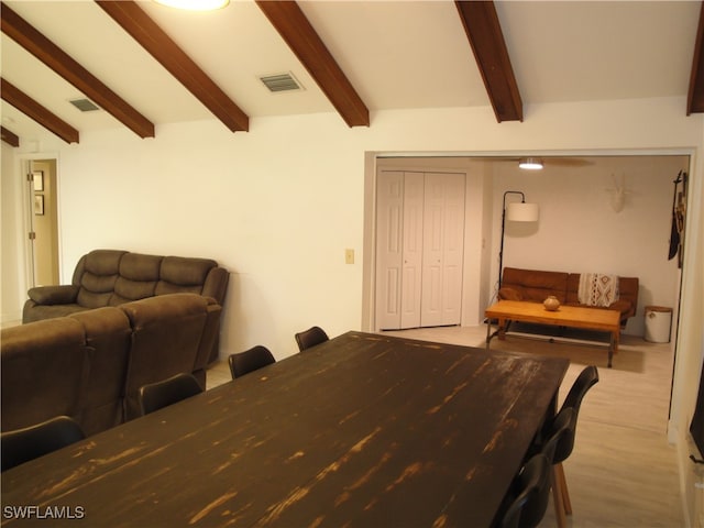 dining space featuring light hardwood / wood-style floors and lofted ceiling with beams