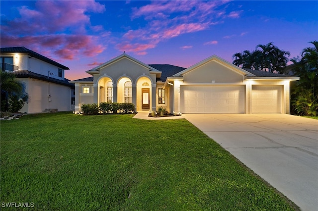 view of front of property with a garage and a yard