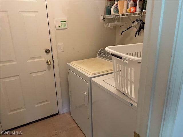 washroom with light tile patterned floors and washer and clothes dryer