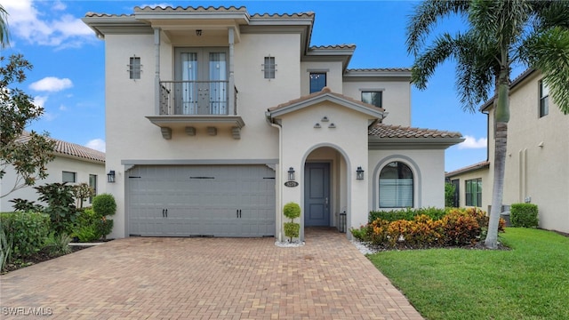 mediterranean / spanish home featuring a garage and a front yard