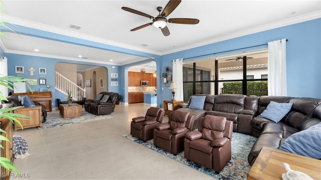 living room featuring ceiling fan, light tile patterned floors, and ornamental molding