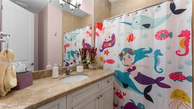 bathroom featuring curtained shower and vanity