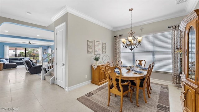 tiled dining room with ceiling fan with notable chandelier and ornamental molding