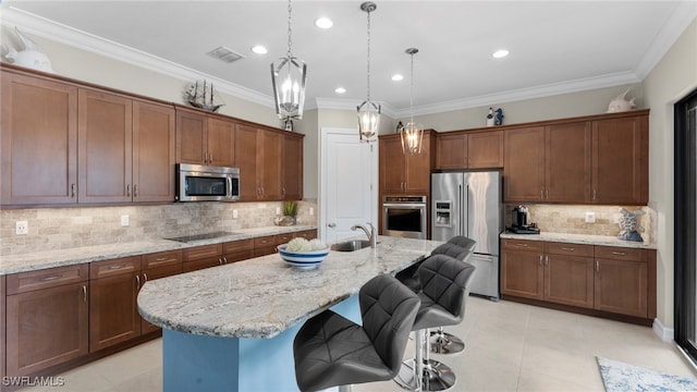 kitchen featuring crown molding, light stone countertops, stainless steel appliances, an island with sink, and a breakfast bar area