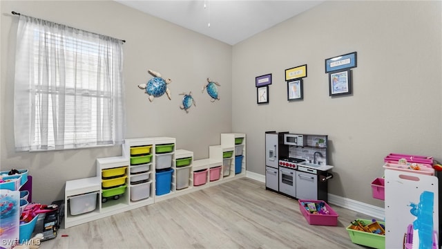 game room with light wood-type flooring and ceiling fan