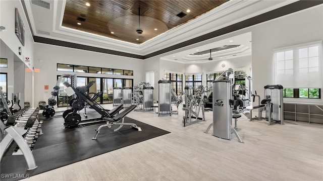 workout area featuring wood ceiling, a raised ceiling, a high ceiling, and crown molding