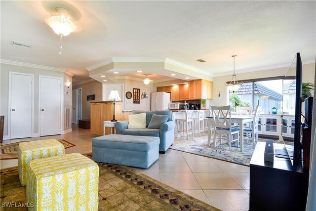 living room with ceiling fan, light tile patterned floors, and ornamental molding