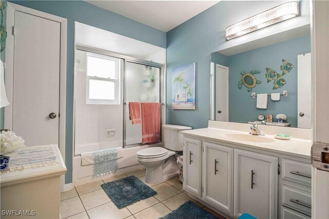 full bathroom with tile patterned floors, toilet, bath / shower combo with glass door, and vanity