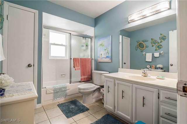 bathroom featuring vanity, tile patterned floors, toilet, and enclosed tub / shower combo