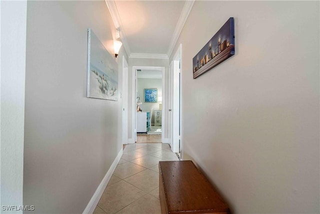 hallway with light tile patterned floors, baseboards, and crown molding