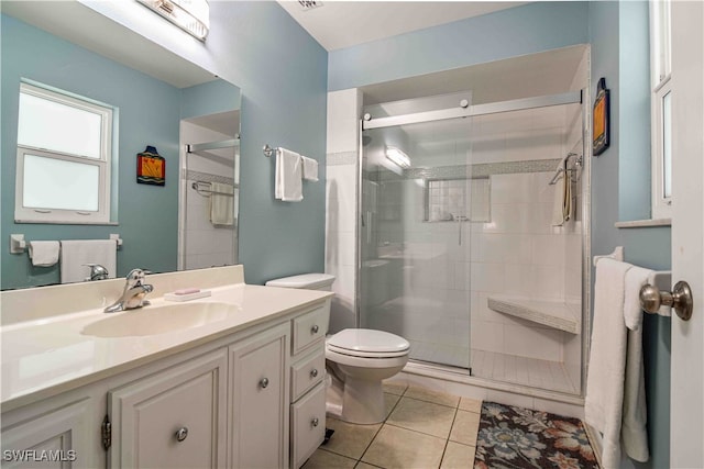 bathroom featuring tile patterned flooring, vanity, toilet, and walk in shower