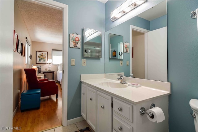 bathroom featuring hardwood / wood-style floors, toilet, a textured ceiling, and vanity