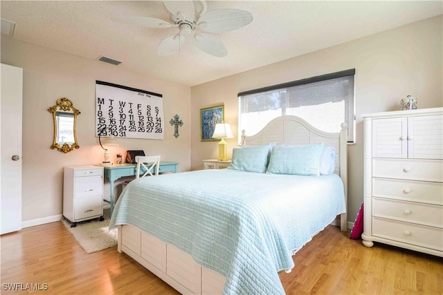 bedroom with ceiling fan, baseboards, visible vents, and light wood-type flooring