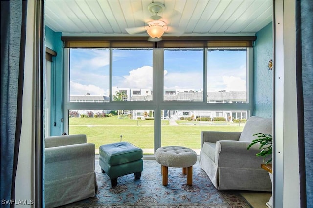 sunroom featuring a wealth of natural light, wood ceiling, and a ceiling fan