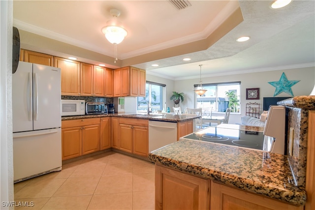 kitchen featuring dark stone countertops, crown molding, white appliances, kitchen peninsula, and sink