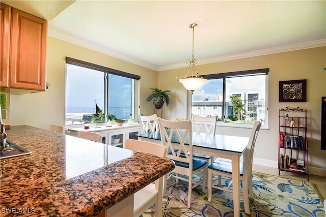 dining room featuring light tile patterned flooring, baseboards, and ornamental molding