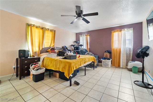 tiled bedroom with a textured ceiling, ceiling fan, and multiple windows