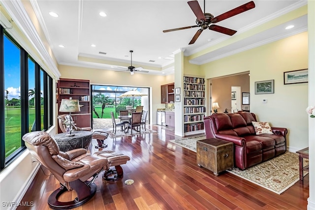 living room featuring dark wood-style floors, visible vents, ceiling fan, crown molding, and a raised ceiling