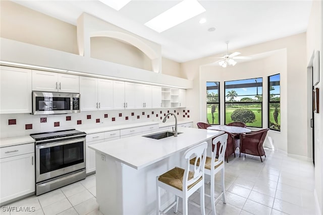 kitchen featuring a sink, open shelves, backsplash, stainless steel appliances, and light countertops