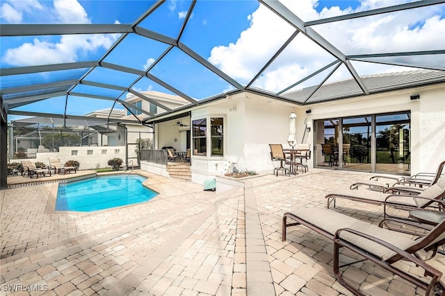 outdoor pool featuring glass enclosure and a patio