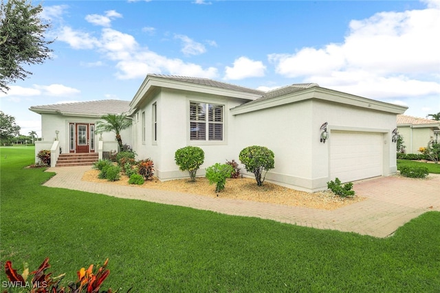 view of home's exterior with a lawn, decorative driveway, a garage, and stucco siding