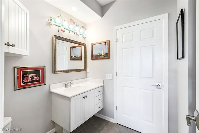 bathroom with tile patterned floors, toilet, vanity, and baseboards