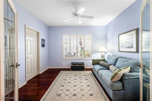 living area featuring a ceiling fan, dark wood-style floors, and baseboards