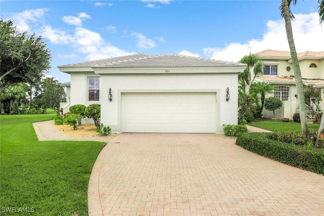 view of front of house with a front lawn, a tiled roof, stucco siding, decorative driveway, and an attached garage