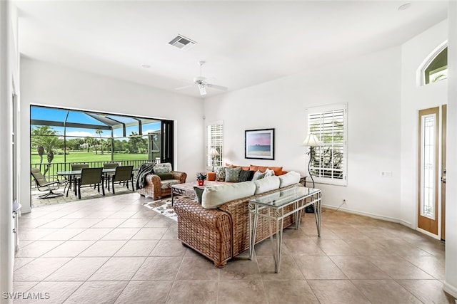 living room with visible vents, ceiling fan, light tile patterned flooring, and a sunroom