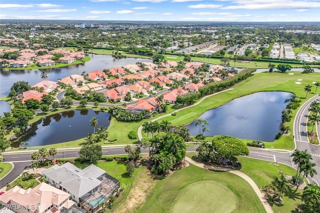 drone / aerial view featuring a residential view, view of golf course, and a water view