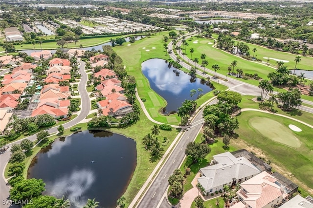 drone / aerial view with a residential view, golf course view, and a water view