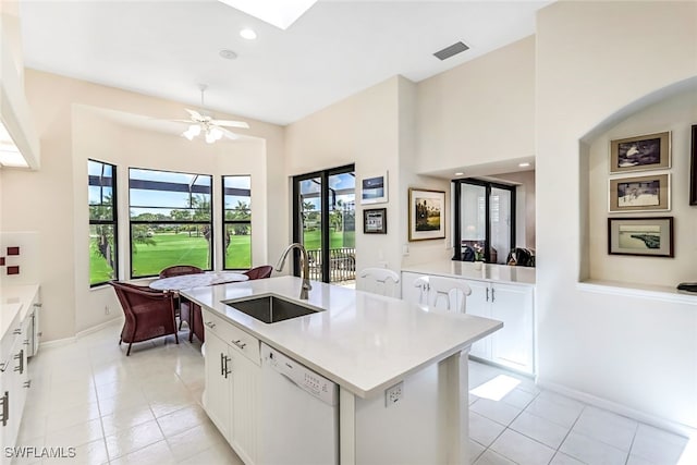 kitchen featuring visible vents, a sink, white cabinets, light countertops, and dishwasher