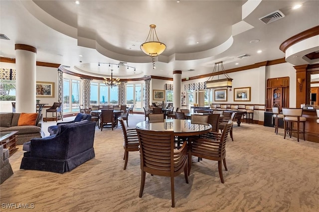 carpeted dining area with ornate columns, plenty of natural light, a chandelier, and ornamental molding