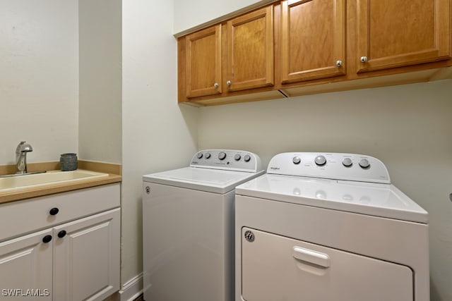 laundry room featuring cabinets, sink, and washing machine and dryer