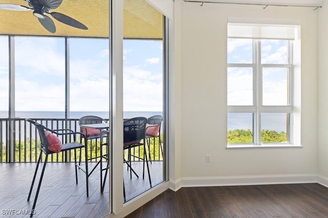 doorway to outside featuring dark hardwood / wood-style flooring, a water view, and ceiling fan