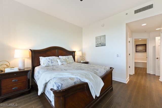 bedroom featuring ensuite bathroom and dark hardwood / wood-style flooring