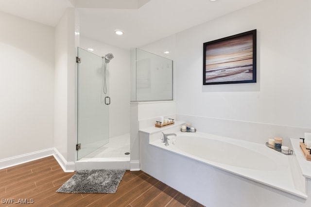 bathroom featuring separate shower and tub and hardwood / wood-style flooring