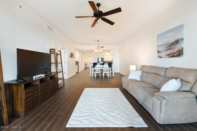 living room featuring ceiling fan with notable chandelier and dark hardwood / wood-style flooring