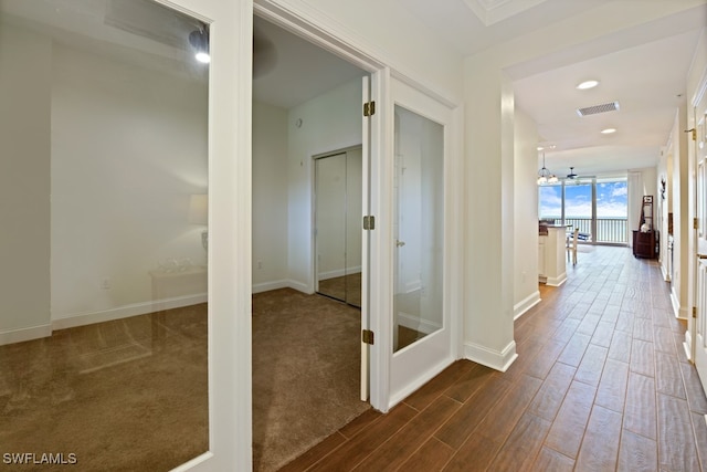 corridor with an inviting chandelier and hardwood / wood-style flooring