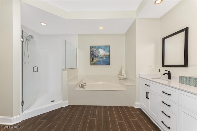 bathroom with hardwood / wood-style flooring, shower with separate bathtub, and vanity