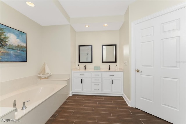 bathroom with a washtub and vanity