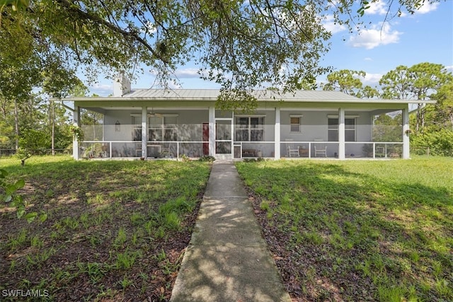 back of property featuring a lawn and a sunroom