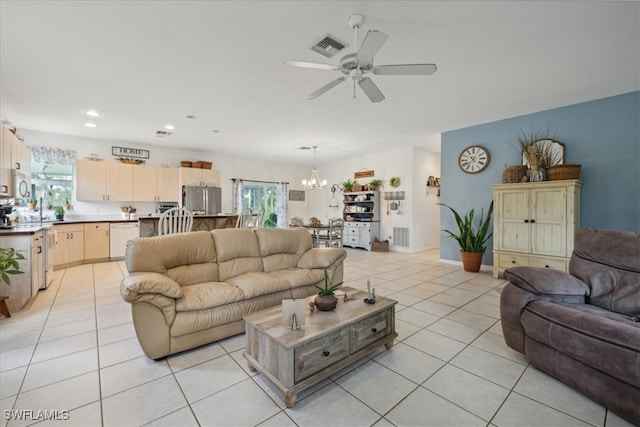 living room with ceiling fan with notable chandelier and light tile patterned flooring